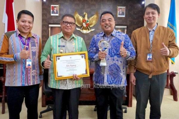  Penjabat Wali Kota Kupang, Fahrensy Funay bersama Kepala Perwakilan BI NTT, Donny Heatubun yang didampingi Deputi Kepala Perwakilan BI NTT, Daniel Agus Prasetyo dan Pratyaksa Candraditya pose bersama sambil memegang penghargaan sebagai TPID Kota IHK Terbaik Tahun 2022 untuk wilayah Nusa Tenggara, Maluku dan Papua dari Presiden RI.