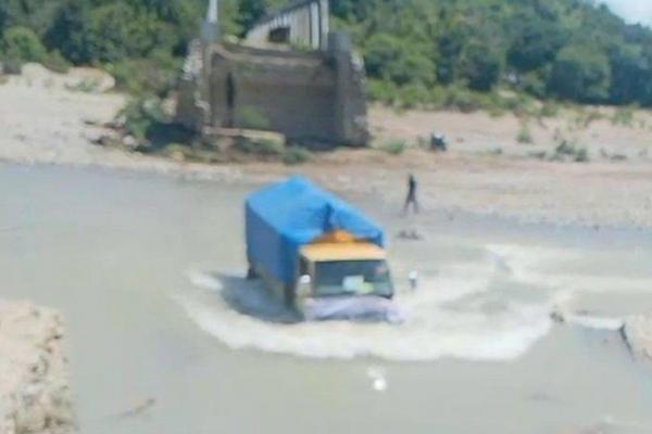 Salah satu truk yang mengangkut logistik Pemilu ke wilayah Kabupaten Kupang harus melewati sungai untuk bisa sampai ke lokasi.