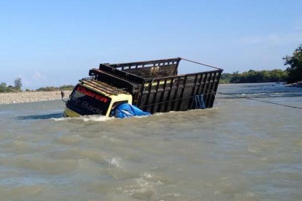 Sebuah mobil truk kayu terjebak dalam sungai Netlopen di Desa Soliu, Kecamatan Amfoang Barat Laut, Jumat (29/3/2024). 