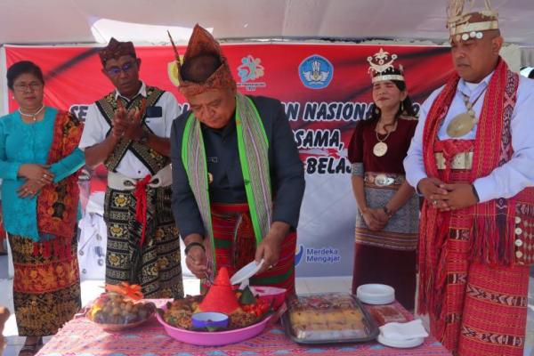 Penjabat Wali Kota Kupang, Fahrensy Funay memotong tumpeng usai memimpin Upacara peringatan Hardiknas ini digelar di Lapangan Kantor Wali Kota Kupang, Kamis (2/5/2024). 