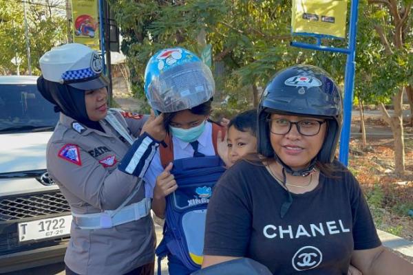 Polwan Polda NTT Bagi Bunga dan Helm Kepada Penguna Jalan 