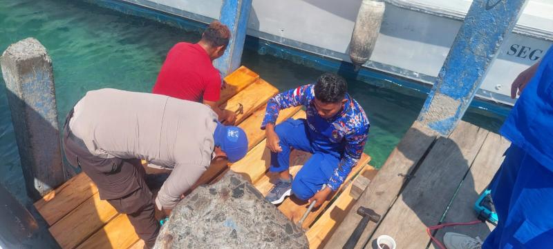 Anggota Satuan Polisi Perairan dan Udara (Polairud) Polres Manggarai Barat bersama-sama dengan warga melakukan perbaikan pada lantai papan dermaga penyeberangan setempat, Jumat (18/10/2024) pagi.
 