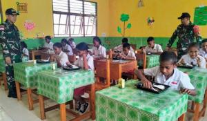 Wadan Satgas Yonif 741/GN, Kapten Inf. Angga Singgih Lestiawan didampingi Dan SSK I Kapten Inf. Yudha Hanggara usai bagikan makan bergizi gratis untuk para siswa-siswi SDI Beitaus, Desa Asumanu, Kecamatan Raihat, Kabupaten Belu perbatasan RI-RDTL, Senin (17/3/2025).