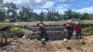 Prajurit TNI Pos Dafala Satgas Yonif 741/GN gotong royong bersama warga bangun jembatan penghubung antar kampung di Desa Dafala, Kecamatan Tastim, Kabupaten Belu perbatasan RI-RDTL, Minggu (26/6/2025).