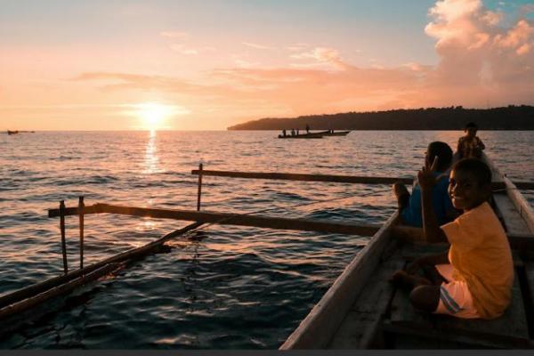 Salah seorang nelayan sementara menangkap ikan dengan memancing di laut. 