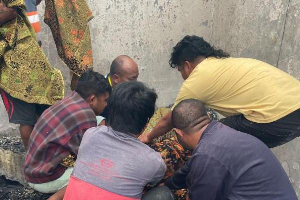 Sejumlah warga membantu mengevakuasi jenazah korban kebakaran Pasar Oinlasi. 