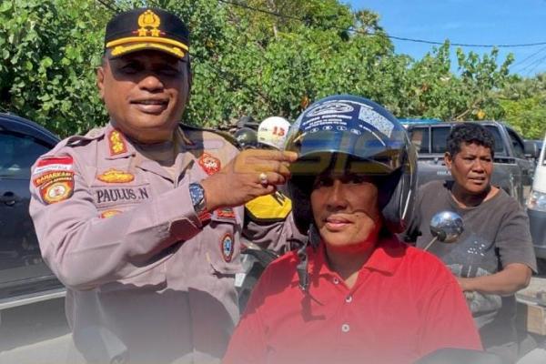 Kapolres Sabu Raijua,  AKBP Paulus Naatonis saat  melakukan operasi Patuh Turangga 2025 dan membagi helm gratis kepada salah satu pengendara sepeda motor. 