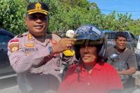 Kapolres Sabu Raijua,  AKBP Paulus Naatonis saat  melakukan operasi Patuh Turangga 2025 dan membagi helm gratis kepada salah satu pengendara sepeda motor.