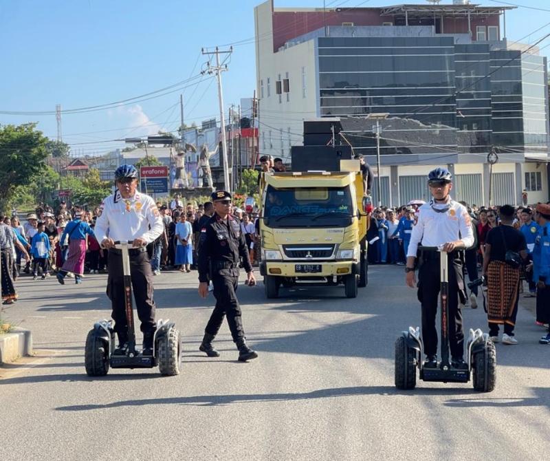 Personel Polres Mabar mengoperasikan skuter listrik untuk mengamankan prosesi Jalan Salib di Labuan Bajo. 