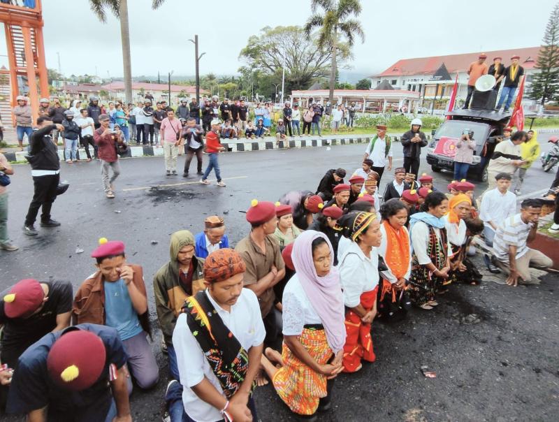 Ibu-ibu dan massa aksi berlutut di aspal depan Polres Manggarai memohon keadilan untuk Restiana Tija. 