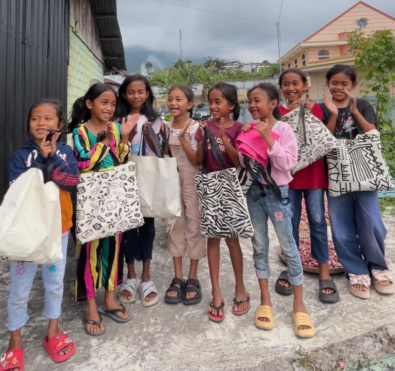 Anak-anak SD tersenyum bahagia usai menerima tas sekolah gratis dari Badjo Badji dan Barberscoot Kumba di Ruteng. 