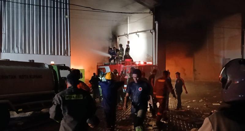 Petugas pemadam kebakaran berusaha memadamkan api yang menghanguskan enam bangunan gudang di Alak 