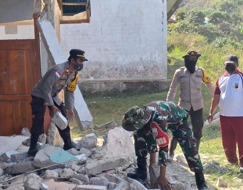 TNI-Polri membersihkan puing bangunan terdampak gempa di SDN Golo Lewe. 